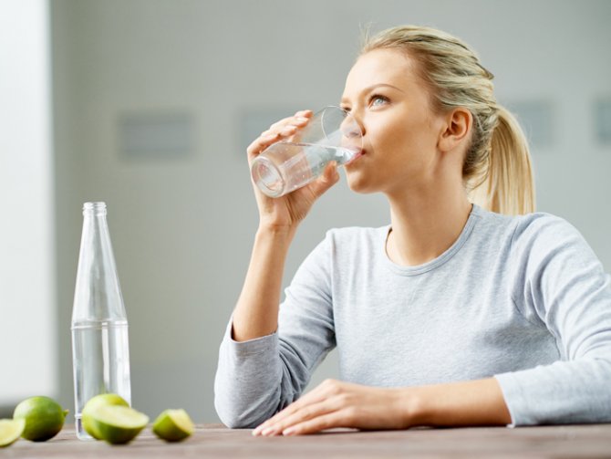 woman-drinking-cup-of-water-limes-on-the-table.jpg